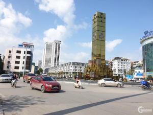 a busy city street with cars and a clock tower at Ha Long Homestay in Ha Long