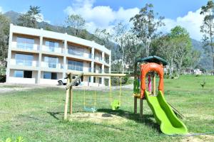 un parque infantil frente a un edificio en Cucuate Hospedaje, en Choachí