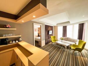 曼谷的住宿－曼谷市集酒店，客厅配有黄色椅子和沙发