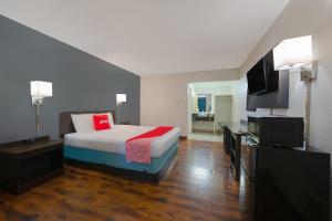 ein Hotelzimmer mit einem Bett und einem Flachbild-TV in der Unterkunft OYO Hotel St Helens OR in Saint Helens