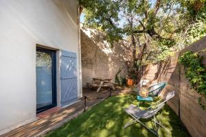 a patio with a table and chairs on the grass at Gîte La Quille - Maison de hameau en Provence pour 4 personnes avec jardin privatif in Le Puy-Sainte-Réparade
