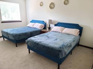 two blue beds in a room with a table at Spacious and peaceful 4 bedroom home in Everett