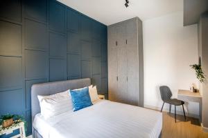 a bedroom with a bed with a blue accent wall at Continew Residence KL CoBNB in Kuala Lumpur