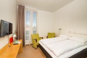 トロンハイムにあるHotel St. Olavのベッドとテレビが備わるホテルルームです。
