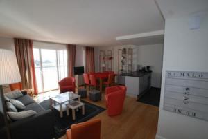 a living room with a couch and red chairs at Résidence Quai Sud-Le Cartier in Saint Malo