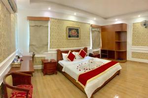ein Schlafzimmer mit einem großen Bett und einem Schreibtisch. in der Unterkunft Nhu Y Hotel in Ho-Chi-Minh-Stadt