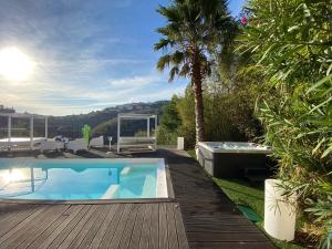 een achtertuin met een zwembad en een houten terras bij VILLA COLINA in Mandelieu-la-Napoule