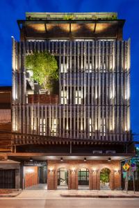 un edificio con una fachada de madera con un árbol en la parte superior en fyn park hotel, en Makkasan