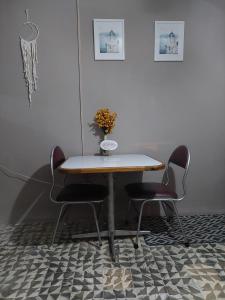 a table with two chairs and a vase on it at Nirvana Hermosa habitación individual e independiente in Guatemala