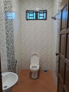 ein Bad mit einem WC, einem Waschbecken und einem Fenster in der Unterkunft ZN Homestay Gong Badak in Kampong Pengkalan Maras