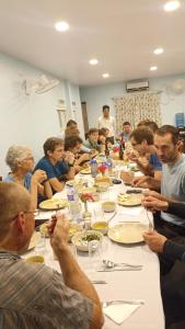 um grupo de pessoas sentadas em torno de uma longa mesa comendo comida em Hotel Megha-Traveller's Village em Nepālganj