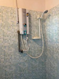 a shower in a bathroom with blue tiles at The Station Tioman in Tioman Island