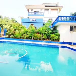 a swimming pool in front of a house at Hilltop 4BHK Villa with Private Pool Near Candolim in Old Goa