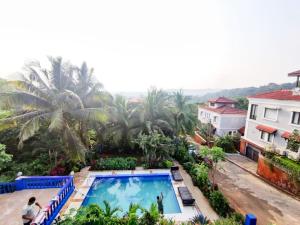 einen Blick über den Pool eines Resorts in der Unterkunft Hilltop 4BHK Villa with Private Pool Near Candolim in Velha Goa