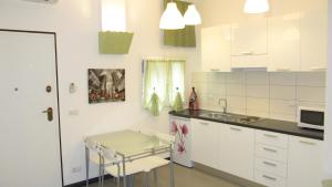 a kitchen with white cabinets and a table and a sink at Casa Verde Lerici in Lerici