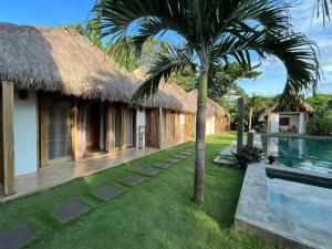 a villa with a palm tree and a swimming pool at SAMADHI Resort & Hydrospa Panglao in Panglao