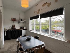 ヒールズビルにあるThe Loft on Main Streetのテーブルと2つの窓があるダイニングルーム