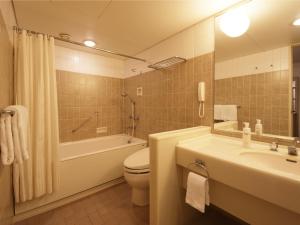 a bathroom with a sink, toilet and shower at Hotel Nikko Narita in Narita