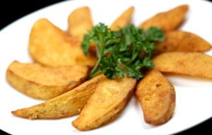a white plate with chips and parsley on top at Laxston Hotel in Yogyakarta