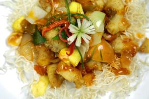 a plate of food with noodles and vegetables at Laxston Hotel in Yogyakarta