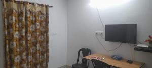 PathanāmthittaにあるB & B Konni, Pathanamthittaの壁にテーブルとテレビが備わる部屋
