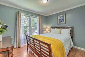 a bedroom with a bed with a yellow blanket and a window at Peaceful Dallas Home with Deck and Charcoal Grill in Hiram