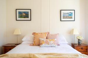 1 dormitorio con 1 cama con sábanas y almohadas blancas en Olive's Cottage, en Windermere