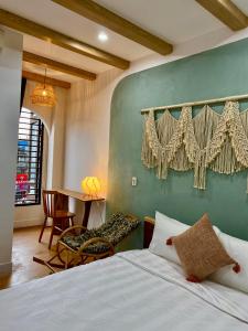 a bedroom with a bed and a table with a chair at Hue Sweethouse 1 Homestay in Hue