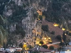 a building on the side of a mountain at night at Bluberry Central Fethiye's apartment in Fethiye