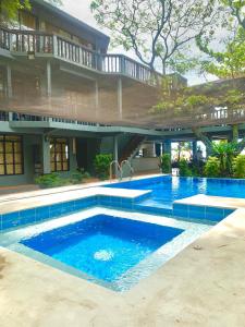 a swimming pool in front of a house at The Henry Resort Taramindu Laiya in Batangas City