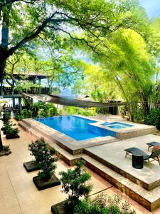 a swimming pool in the middle of a garden at The Henry Resort Taramindu Laiya in Batangas City