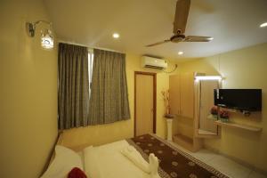 a hotel room with a bed and a television at Nadanam Inn in Puducherry