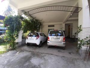 zwei kleine Autos, die vor einem Gebäude geparkt sind in der Unterkunft Tokari Home Stay in Guwahati