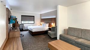 ein Hotelzimmer mit einem Bett und einem Sofa in der Unterkunft Estherville Hotel & Suites in Estherville
