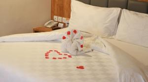 a stuffed animal is sitting on a bed at Beverly Hotel Batam in Nagoya