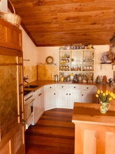uma cozinha com armários brancos e tectos em madeira em Tracy's Boutique B&B Farmstay em Wellsford