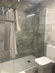 y baño con ducha, aseo y toallas. en Casa Villamartin Plaza Apartment, en Villacosta