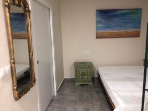 Schlafzimmer mit einem Bett und einem Spiegel in der Unterkunft VillavistasB in Hornachuelos