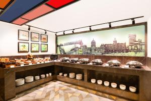 a restaurant with a buffet of food on display at Lemon Tree Hotel, Kalina, Mumbai in Mumbai