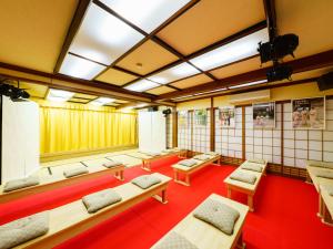 uma sala com uma fila de bancos e mesas em Ureshino Onsen Kotobukiya em Ureshino