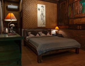 a bedroom with a bed and a brick wall at Pondok Pitaya Balian Hotel in Selemadeg