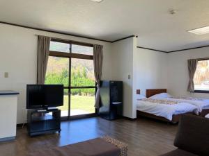 a bedroom with a bed and a flat screen tv at Sea Tiger Island Inn Shodoshima in Shodoshima