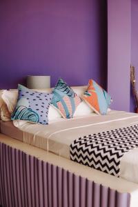 una cama con almohadas coloridas encima en Belika Beach Club, en Hiriketiya