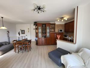 un soggiorno e una cucina con tavolo e divano di Villa Olivo a Limone sul Garda