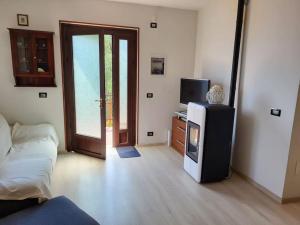 sala de estar con TV y puerta a una habitación en Villa Olivo, en Limone sul Garda