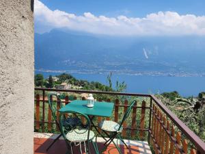 un tavolo e sedie su un balcone con vista sull'acqua di Villa Olivo a Limone sul Garda
