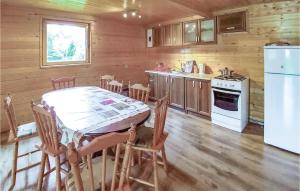 una cucina con un tavolo e un frigorifero bianco di Four-Bedroom Holiday Home In Choczewo a Choczewo