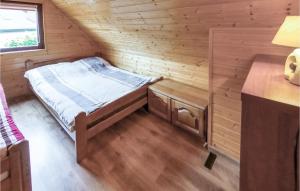 ChoczewoにあるAmazing Home In Choczewo With Kitchenのログキャビン内のベッド1台が備わる小さな客室です。