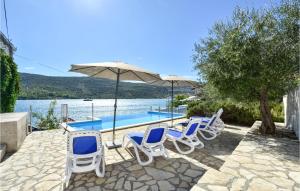 un grupo de sillas, una sombrilla y una piscina en Nice Home In Poljica With House Sea View en Marina