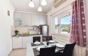 cocina con mesa, sillas y ventana en Nice Home In Poljica With House Sea View en Marina